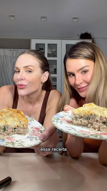 Flávia e Natani segurando pratos com torta de frango proteica